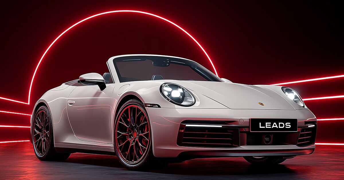 White convertible sports car with a LEADS plate under red neon light